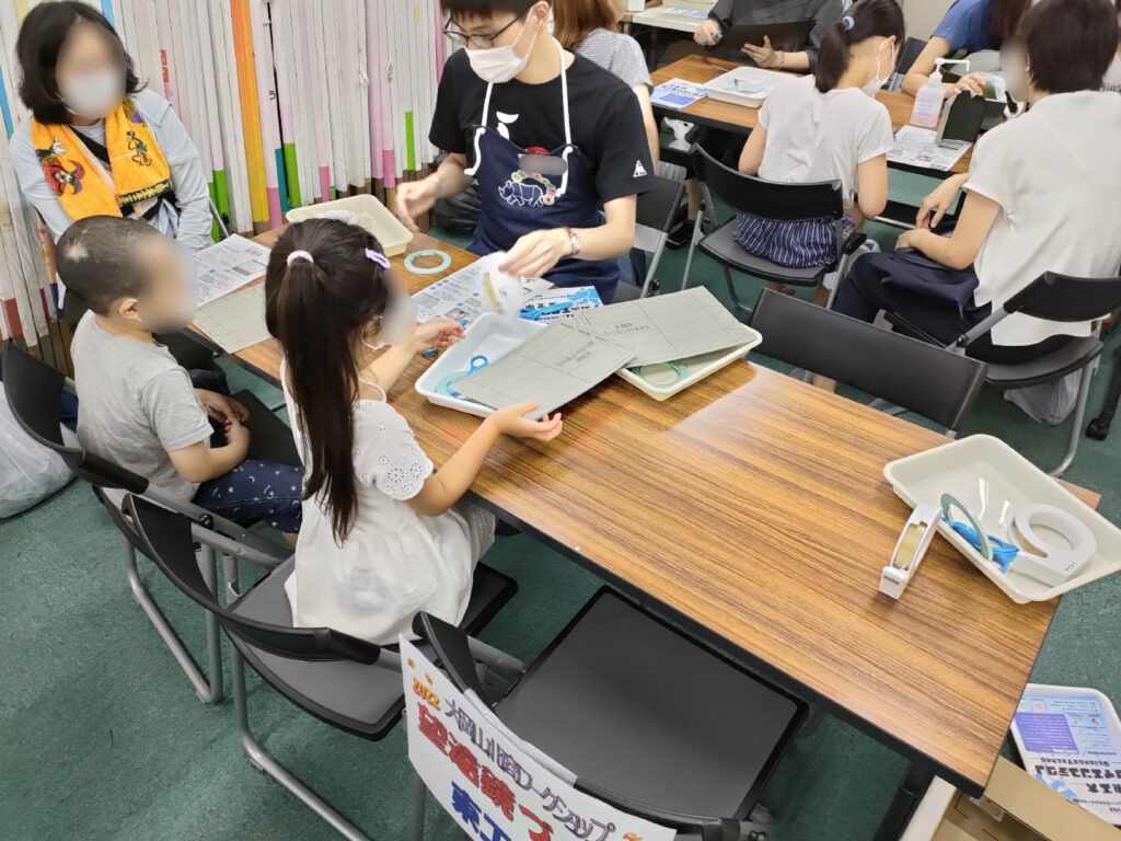 子どもたちがスタッフと工作材料の確認をしている様子