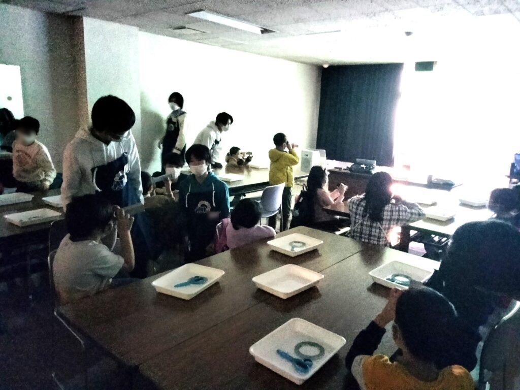 ピンホールカメラを覗く子どもたち