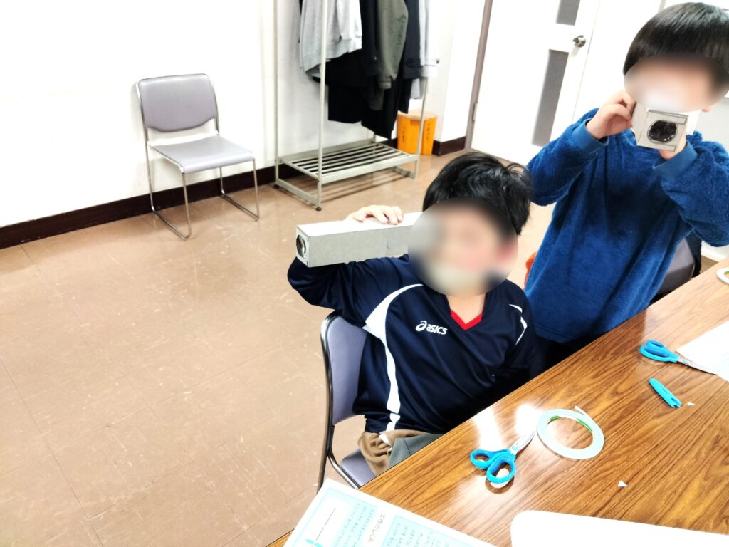 完成したカメラオブスキュラで遊ぶ子どもたち