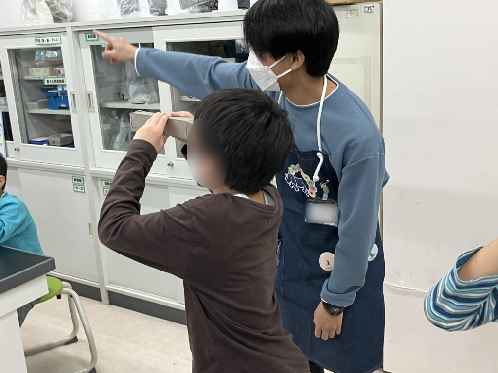 完成した「望遠鏡」を覗く子ども