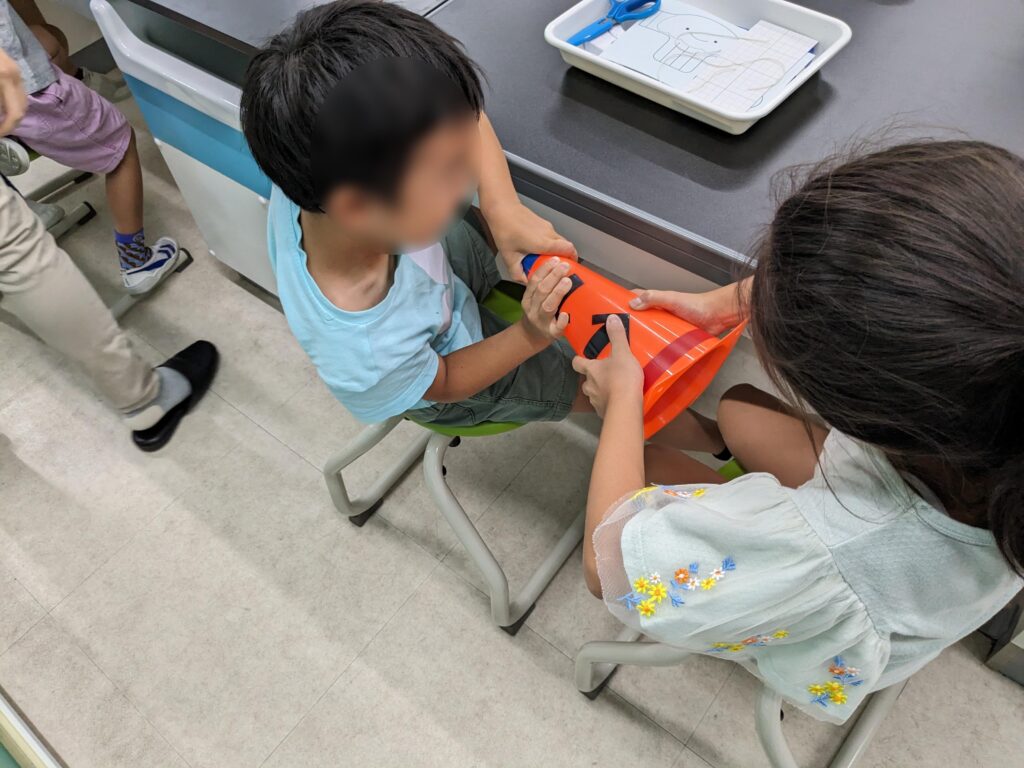 三角コーンを使って力比べをする子どもたち