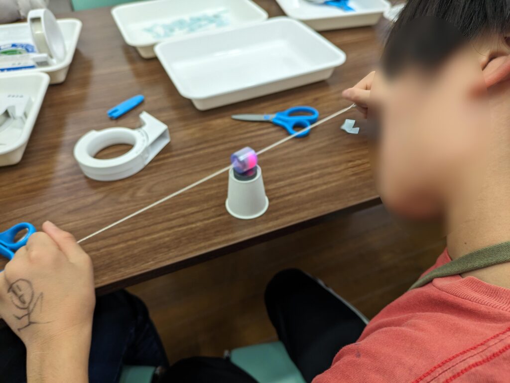 「光るぶんぶんごま」を光らせる子ども