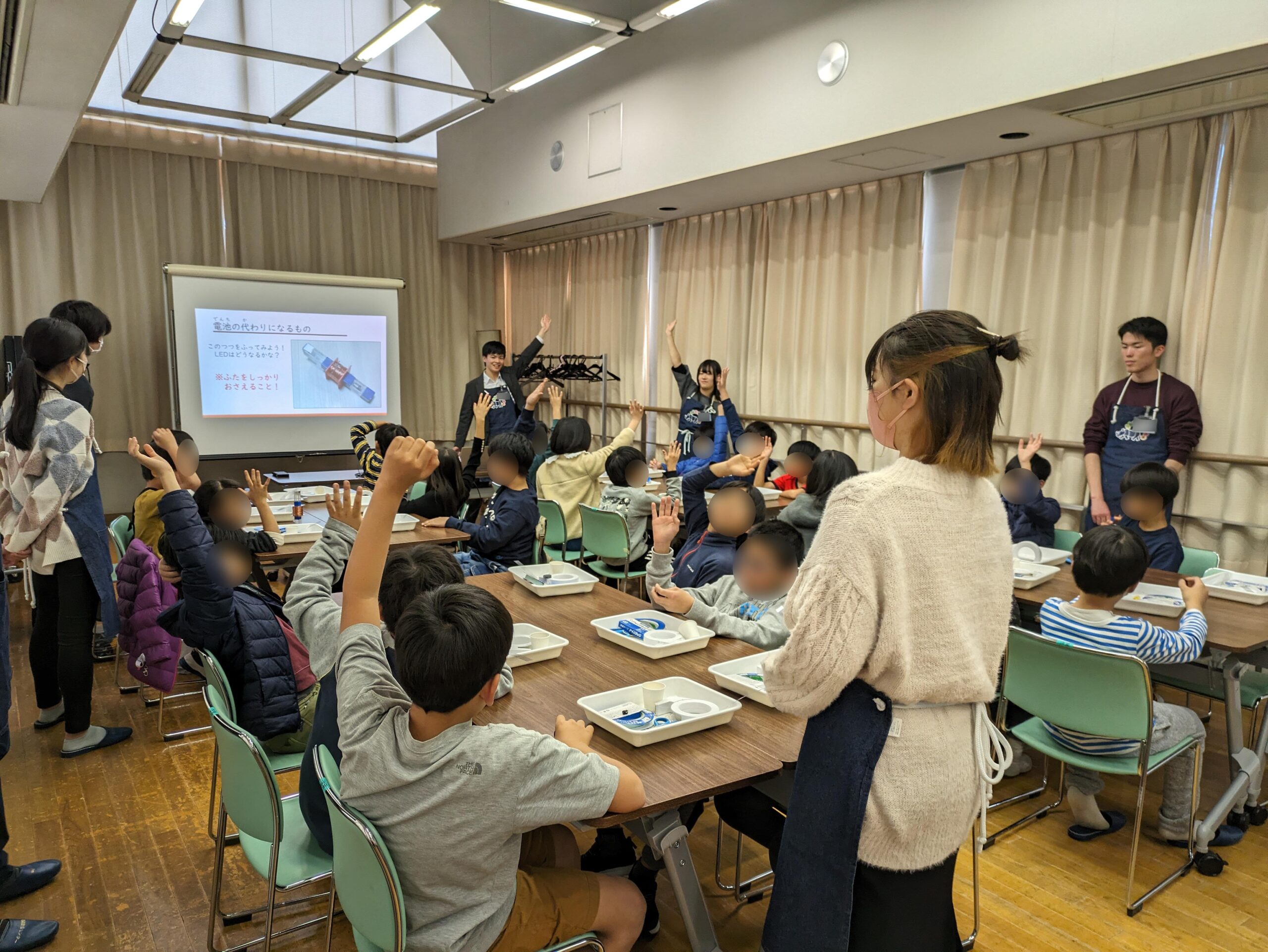 講師の話を聞いて手を挙げる子どもたち