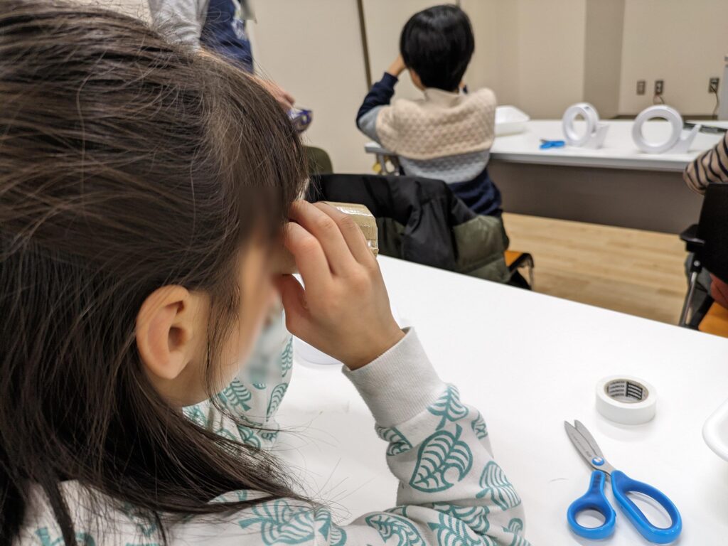 完成した「偏光万華鏡」を覗く子ども