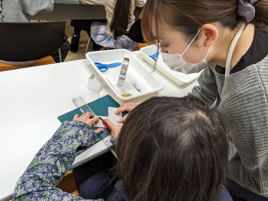 鏡をプラスチックカッターで削る子ども